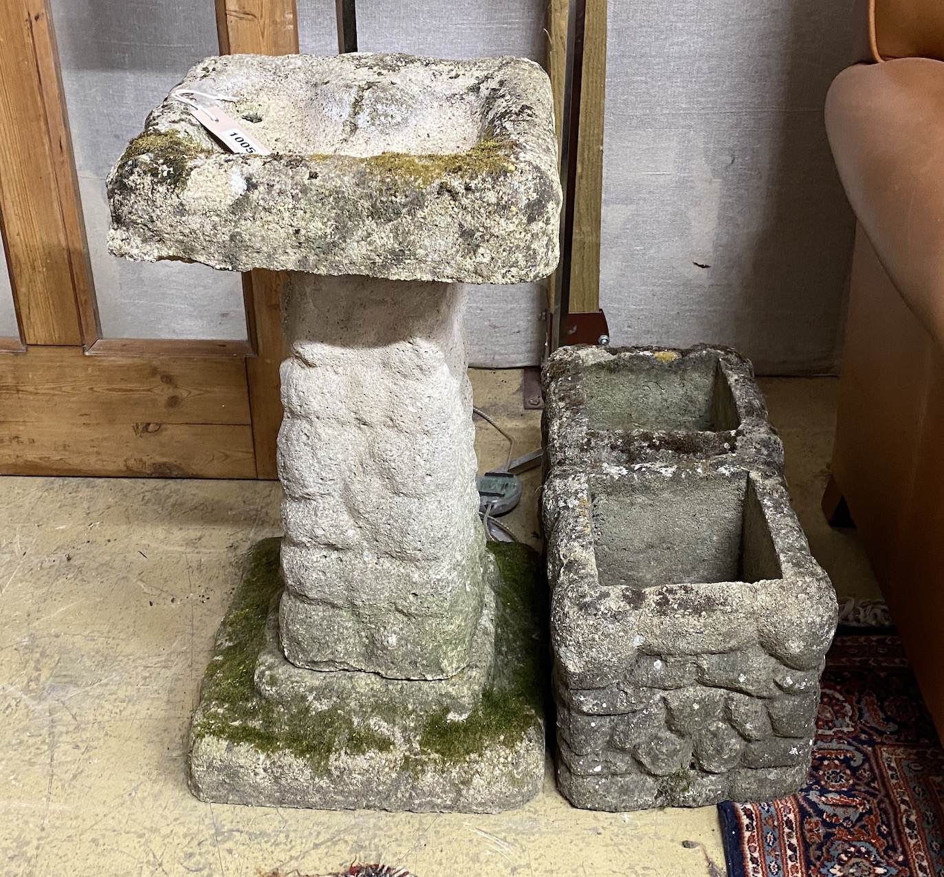 A pebble effect reconstituted stone bird bath, height 67cm together with two similar smaller square planters